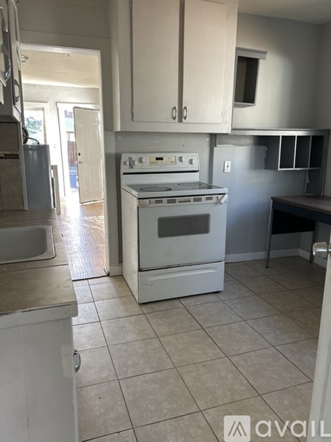 A kitchen with a white oven and white cabinets.