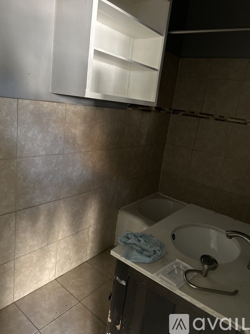A bathroom with a tiled wall and a white sink.