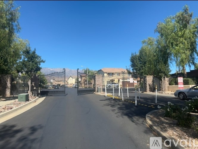 A gated entrance to a residential area with a clear blue sky above.
