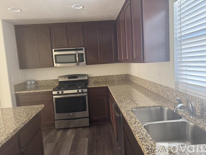 A kitchen with brown cabinets and a stainless steel sink.