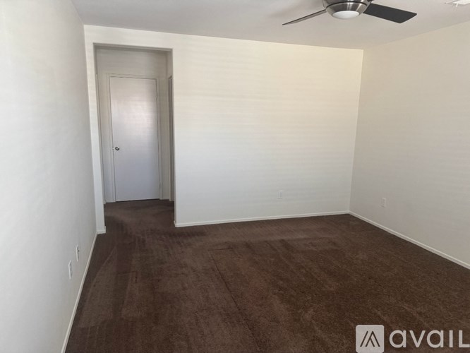 A room with a brown carpet and a white door.