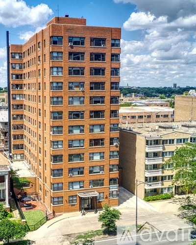 A tall red brick building with many windows and balconies.