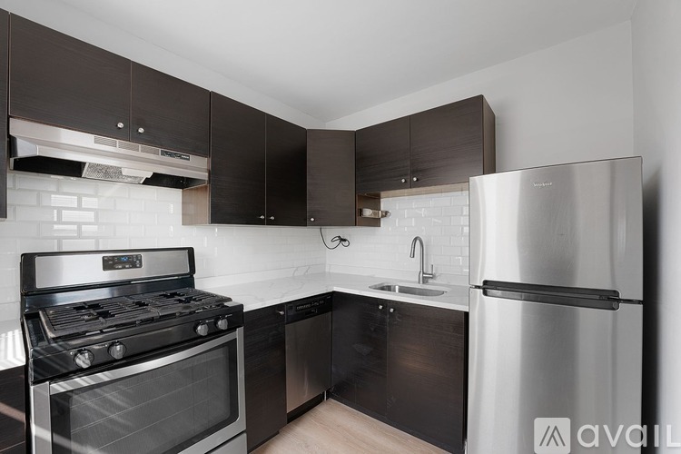 A modern kitchen with a stainless steel refrigerator, oven, and sink.