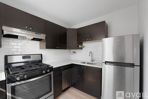 A modern kitchen with a stainless steel refrigerator, oven, and sink.