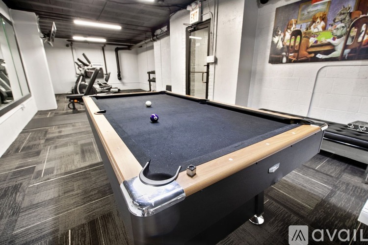 A pool table in a room with a painting on the wall.