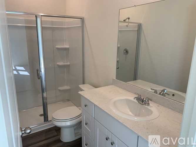 A bathroom with a toilet, sink, and shower.