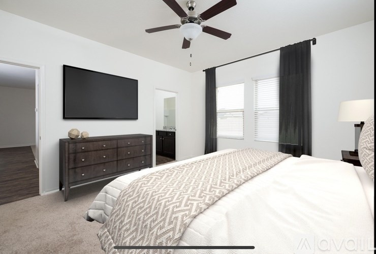 A bedroom with a large bed and a flat screen TV mounted on the wall.