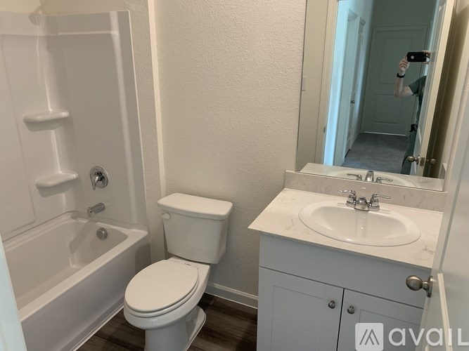 A bathroom with a toilet, sink, and bathtub.