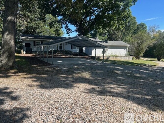 A house with a gravel driveway in front of it.