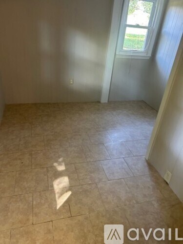 A room with a tiled floor and a window.