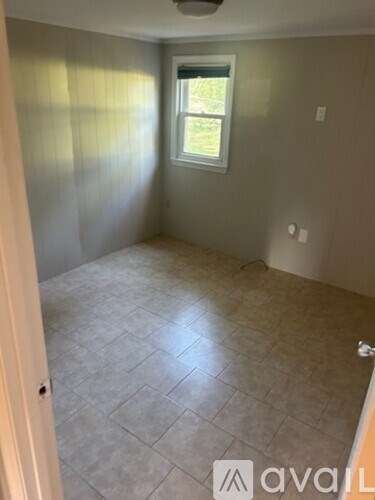 A room with a tiled floor and a window.