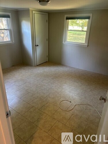 A room with a door, a window, and a tiled floor.