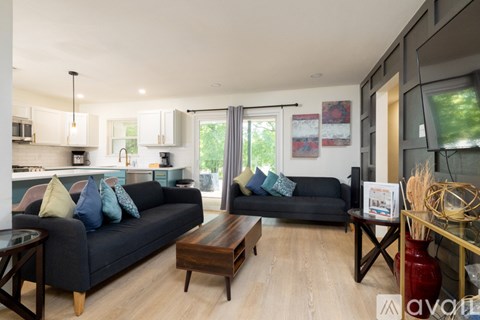 A living room with a black couch and a coffee table.