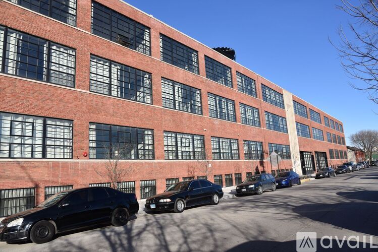 A row of cars parked in front of a red brick building.
