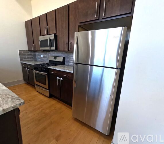A kitchen with a stainless steel refrigerator, microwave, oven, and dishwasher.