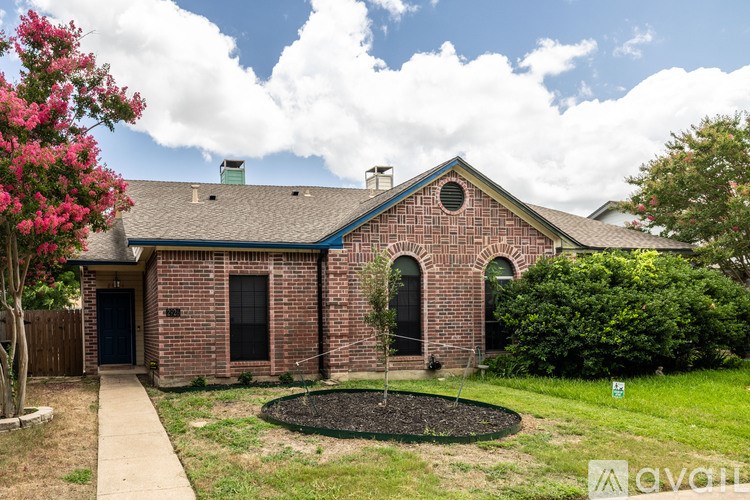 A house with a brick facade and a green lawn in front.