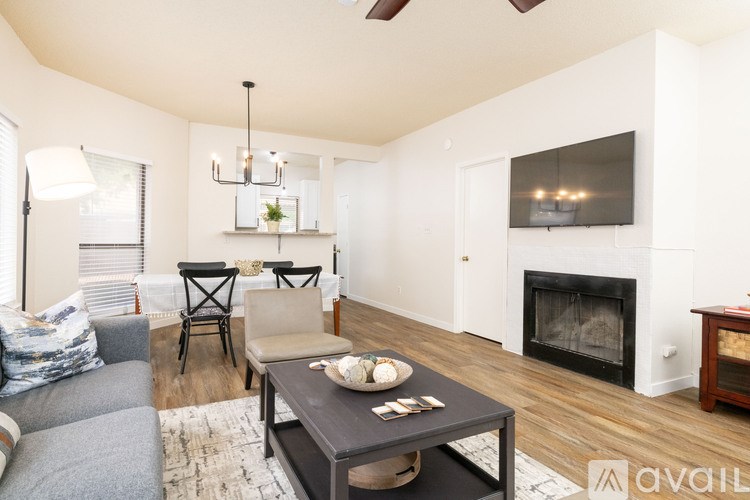 A modern living room with a grey sofa, a black coffee table, and a fireplace.