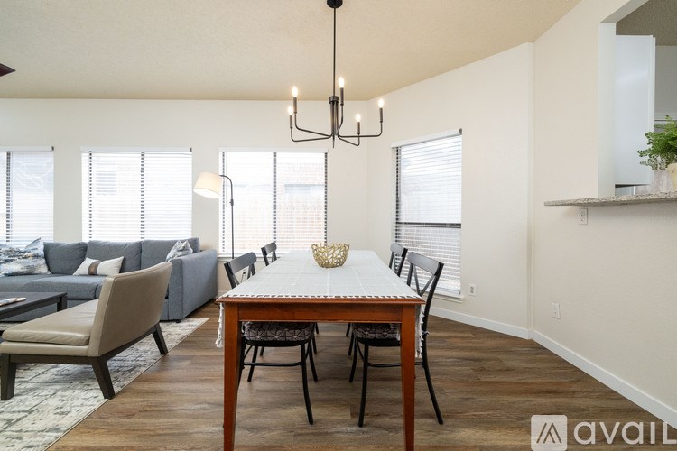 A dining room with a wooden table and chairs.
