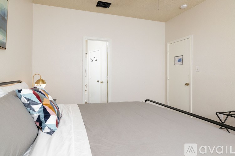 A bedroom with a bed, pillow, and a lamp.