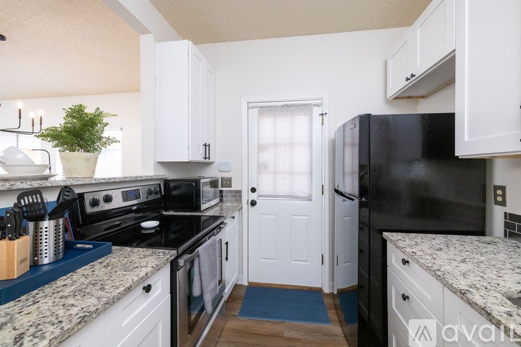 A kitchen with black appliances and white cabinets.
