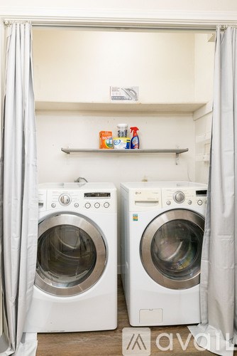 Two washing machines are in a dry cleaning closet.