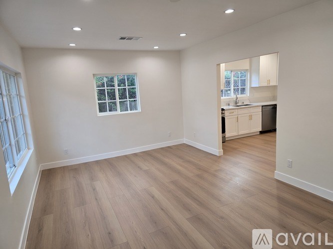 A spacious room with wooden flooring and a window.
