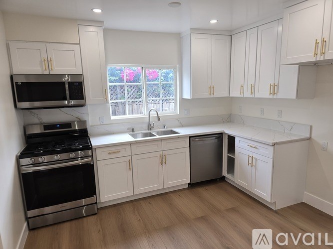 A kitchen with white cabinets and a black stove top oven.