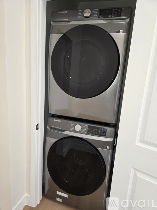 A black and silver front loading washing machine with a control panel on top.