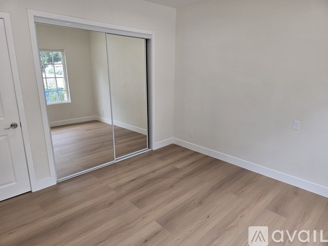 A room with a sliding door and wooden flooring.