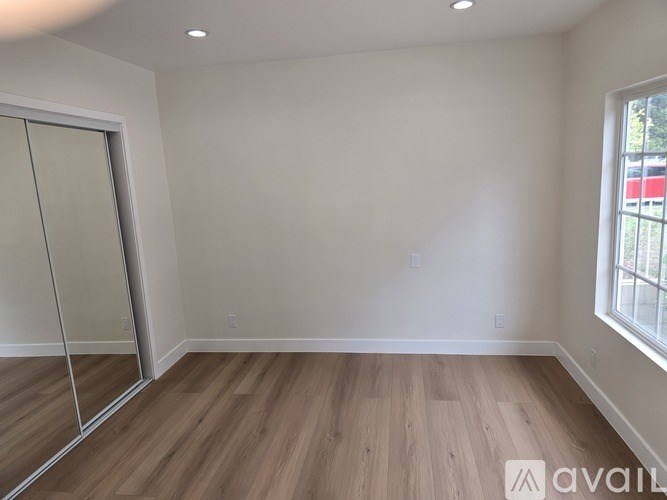 A room with wooden flooring and a sliding glass door.