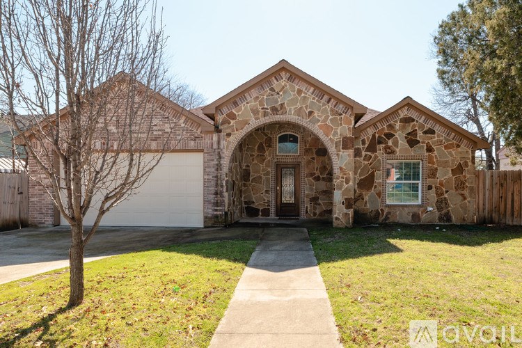 A house with a stone facade and a white garage door.