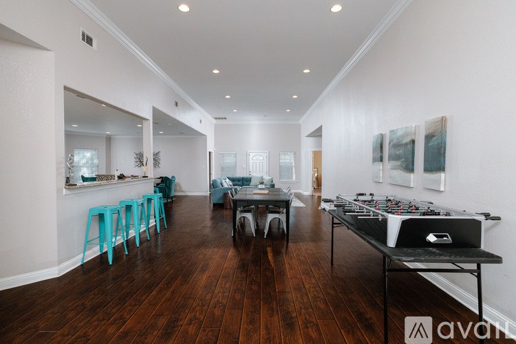 A spacious room with wooden floors and a DJ table in the foreground.