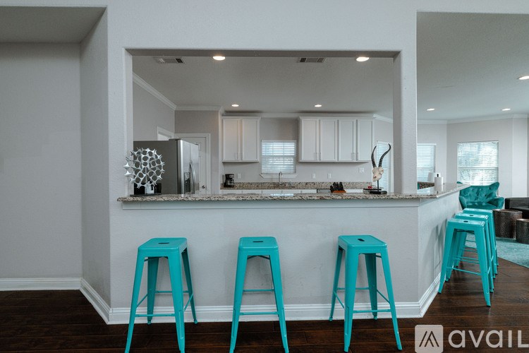 A kitchen with a bar area and blue stools.