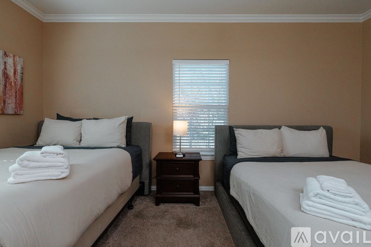 Two twin beds with white towels on them in a room.