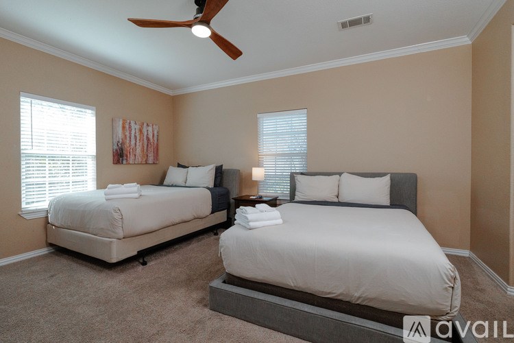 A bedroom with two beds and a ceiling fan.