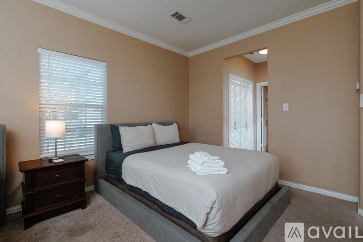 A bedroom with a bed, nightstand, and window.