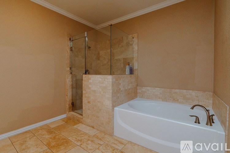 A bathroom with a white bathtub and a glass shower door.