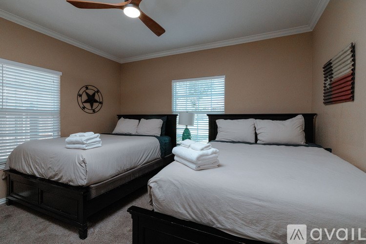 Two twin beds with white towels on them in a room.