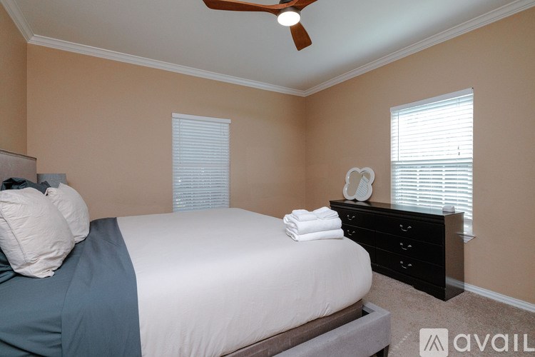 A bedroom with a bed, dresser, and window.