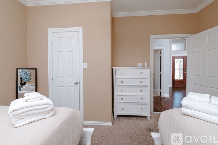 A bedroom with two beds and a dresser.