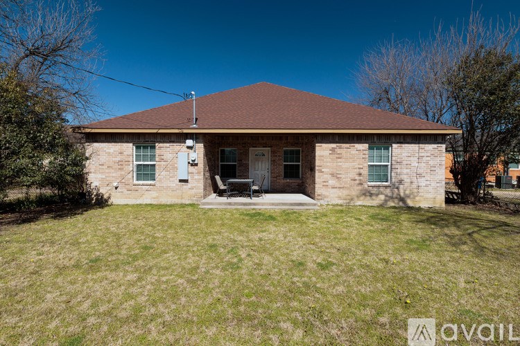 A house with a brown roof and a lawn in front.