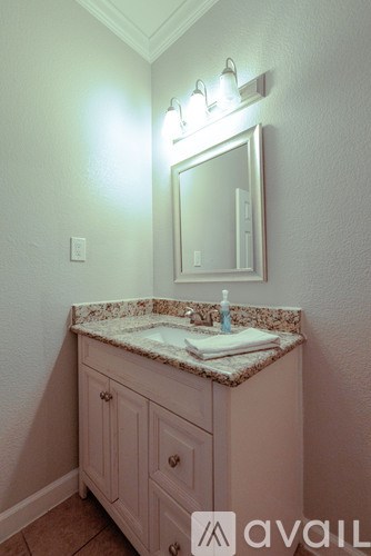 A bathroom vanity with a marble top and a mirror above it.