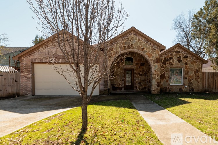 A house with a stone facade and a garage door.