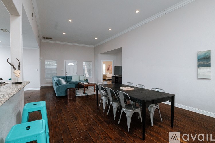 A modern dining room with a black table and chairs.