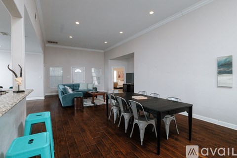 A modern dining room with a black table and chairs.
