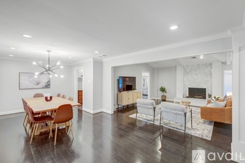 A modern living room with a dining table and chairs.