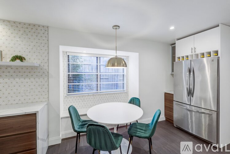 A kitchen with a table and chairs.