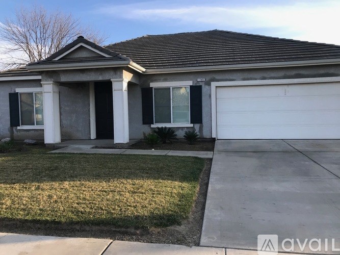 A house with a garage and a driveway in front.