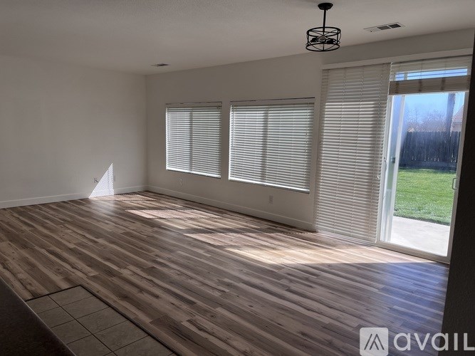 A room with wooden flooring and white walls.