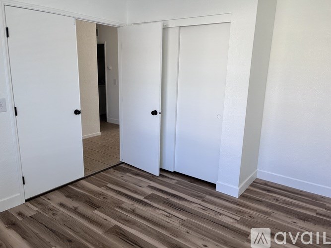 A room with two white doors and a wooden floor.